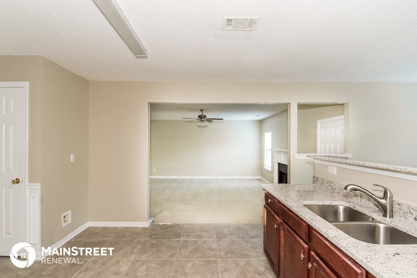 the kitchen and living room of an empty house