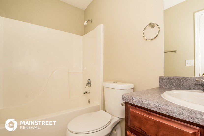 a bathroom with a toilet and a tub and a sink