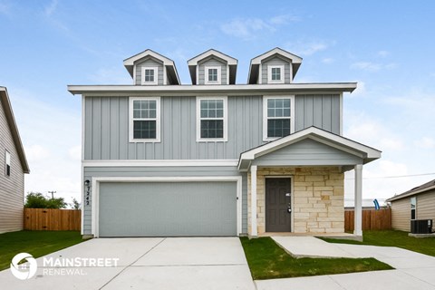 a gray house with three dormers on top of it