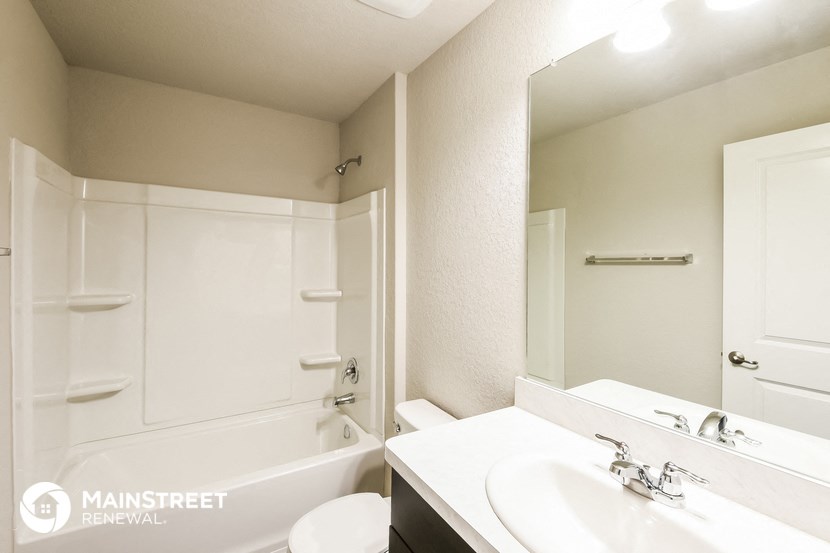 a bathroom with a sink and a tub and a mirror