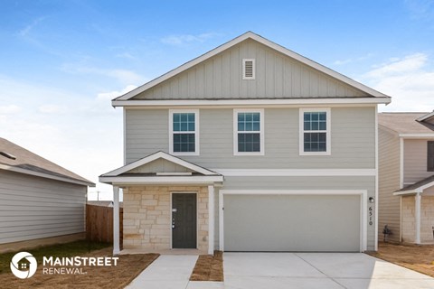 the exterior of a home with a gray house and a stone driveway