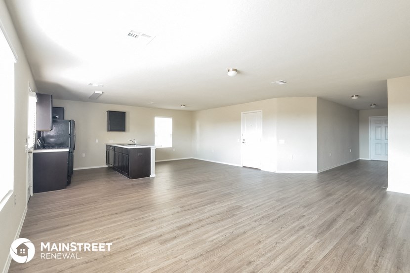 an empty living room with white walls and wood flooring