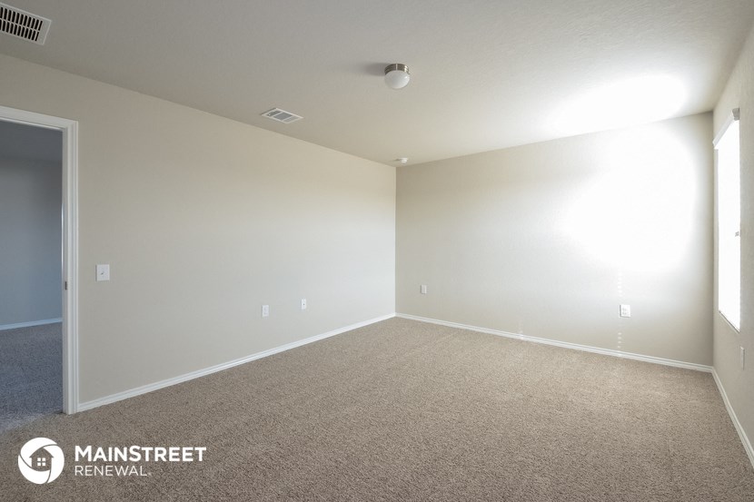 an empty room with carpet and a white wall