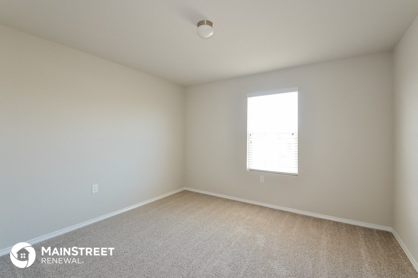 an empty room with white walls and a window