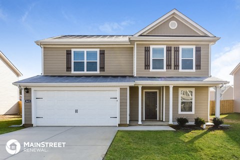 a beige house with a white garage door and a lawn