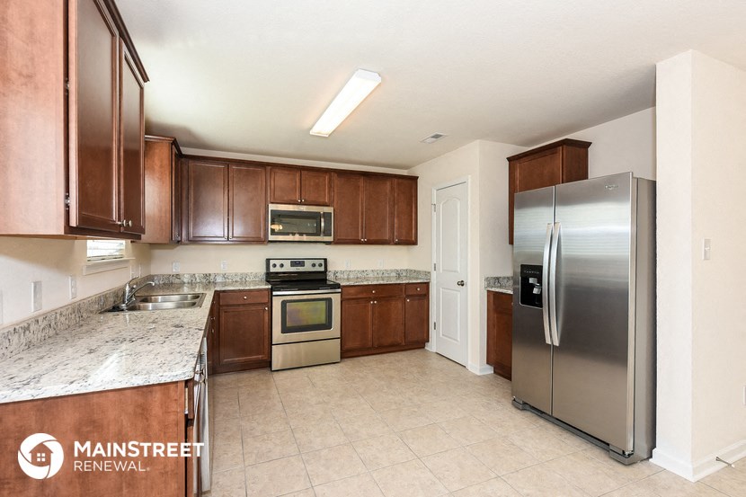 a large kitchen with stainless steel appliances and marble counter tops