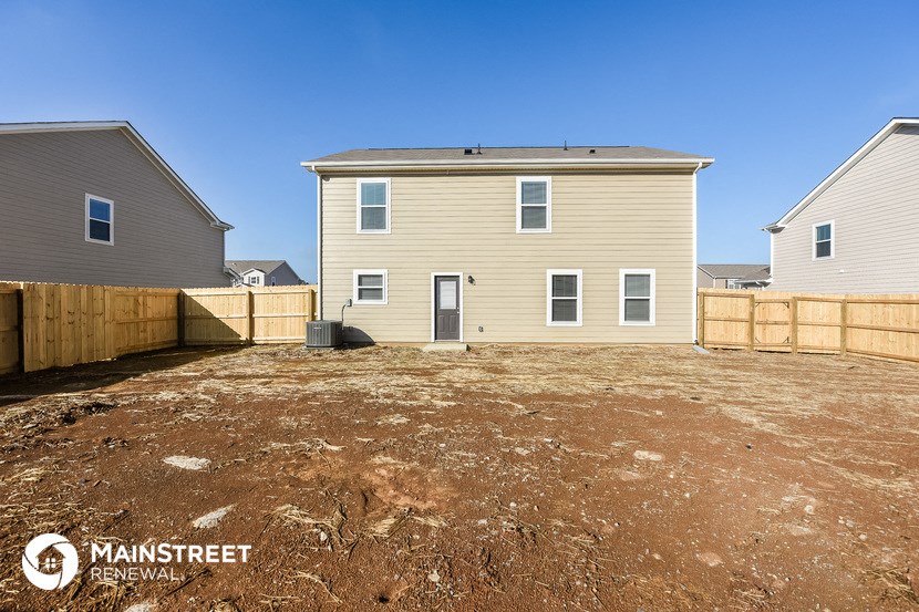 a backyard with a house and a wooden fence