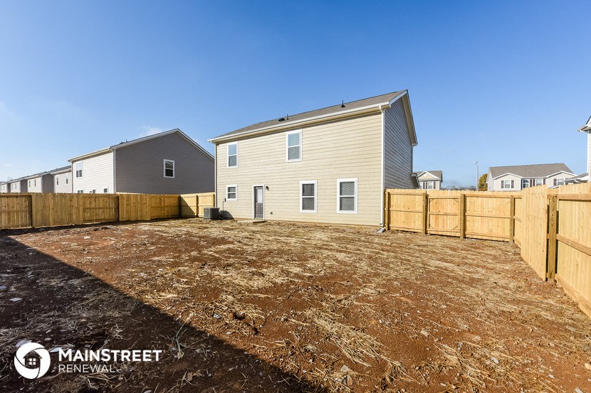 a backyard with a house and a wooden fence