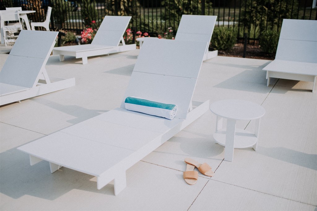 an outdoor seating area with white chairs and a white table