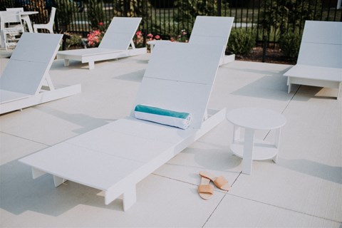 an outdoor seating area with white chairs and a white table