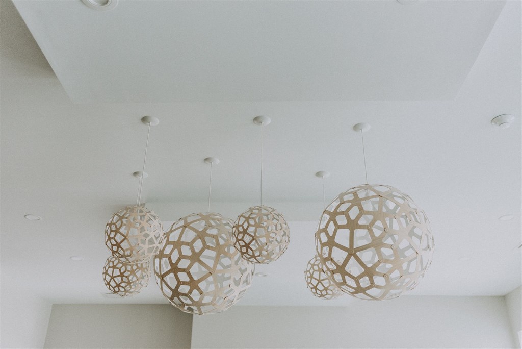 three large white pendants hanging from a white ceiling