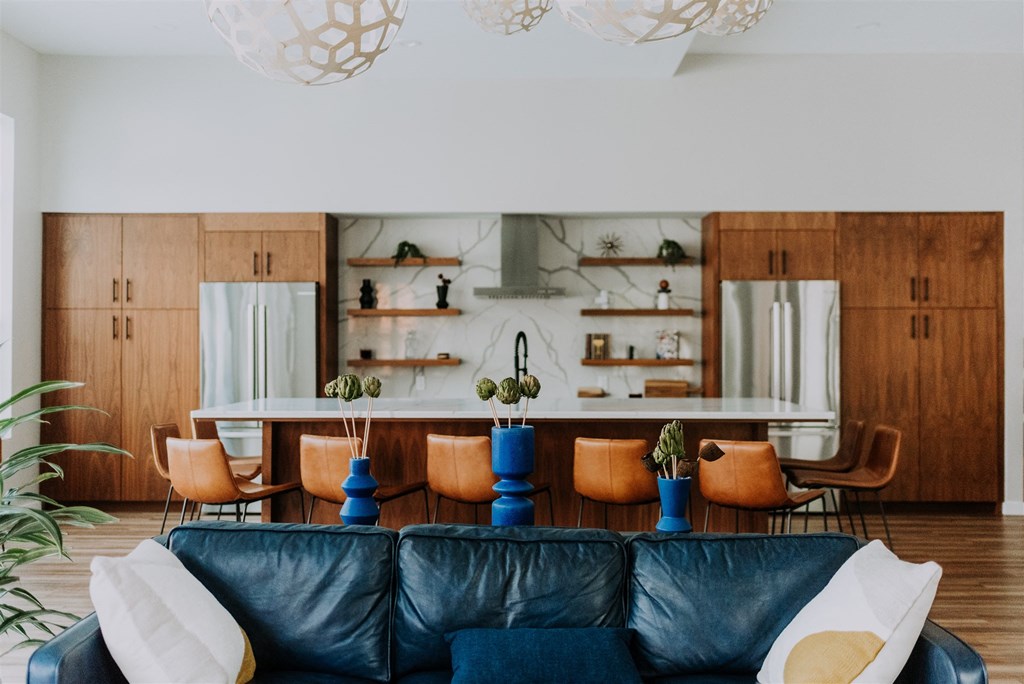 a living room with a leather couch and a table with chairs
