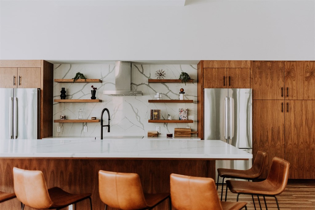 a kitchen with a marble counter top and leather chairs