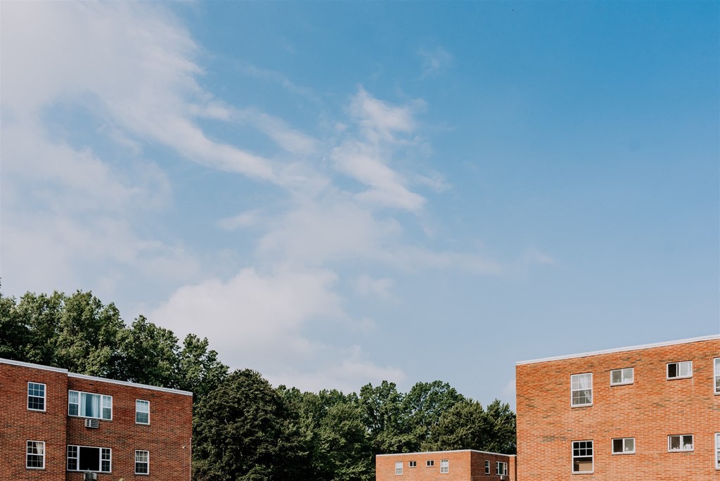 a row of brick apartment buildings against a blue sky
