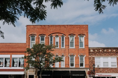 a red brick building with a tree in front of it