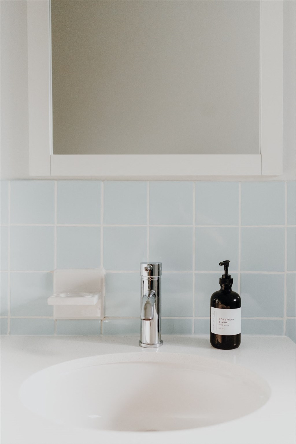 a bathroom sink with a bottle of soap and a soap dispenser