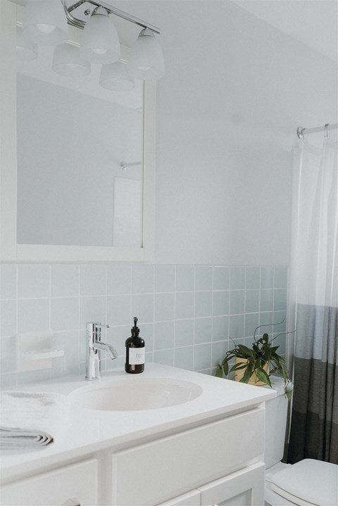 a white bathroom with a sink and a mirror