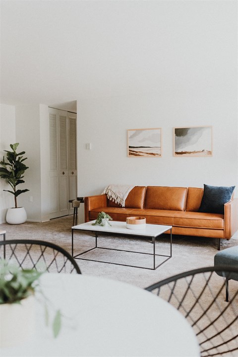 a living room with a brown couch and a table