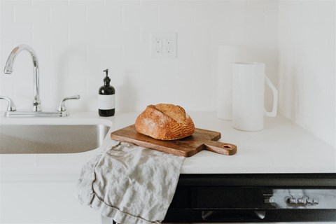 a loaf of bread on a cutting board on a kitchen counter