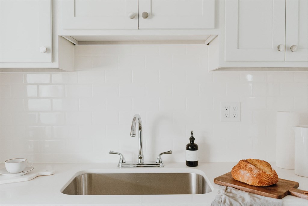 a loaf of bread on a cutting board in a kitchen sink