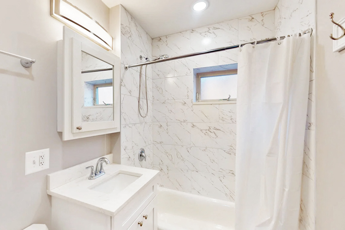 a bathroom with a shower and a sink and a mirror
