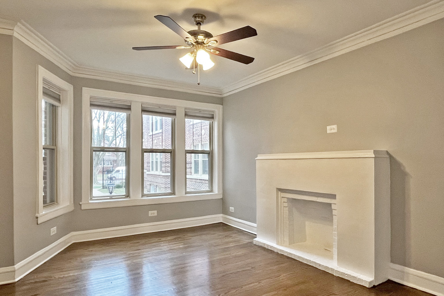 A room with a fireplace and a ceiling fan.