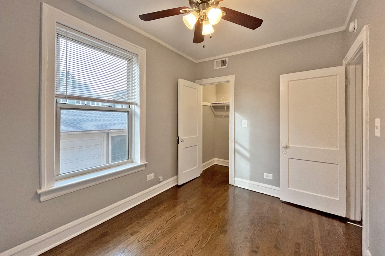 A room with a ceiling fan and a window.