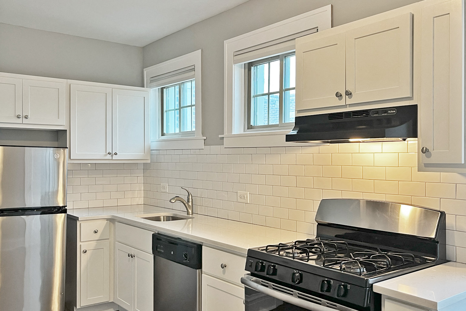 A kitchen with a black stove and white cabinets.