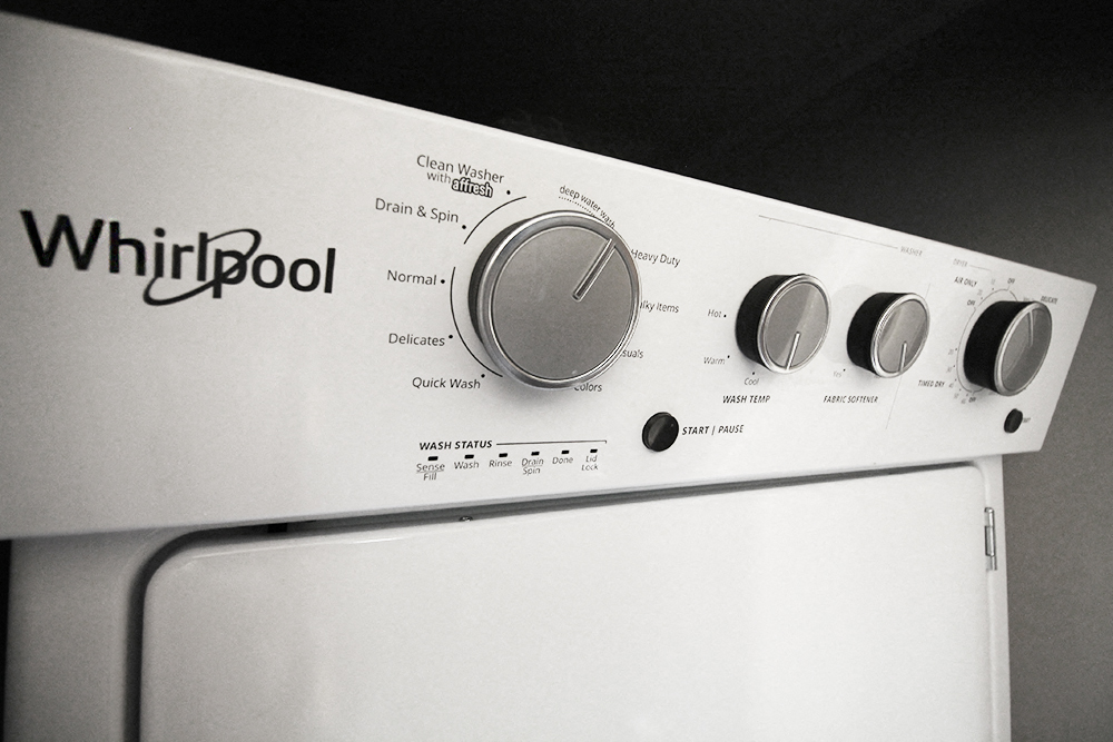 a white whirlpool oven with four different knobs on it
