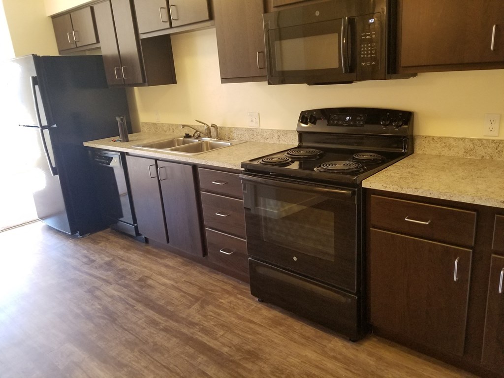 an empty kitchen with a stove and a sink