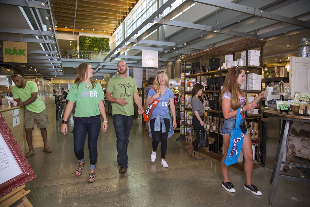 a group of people walking through a shopping mall