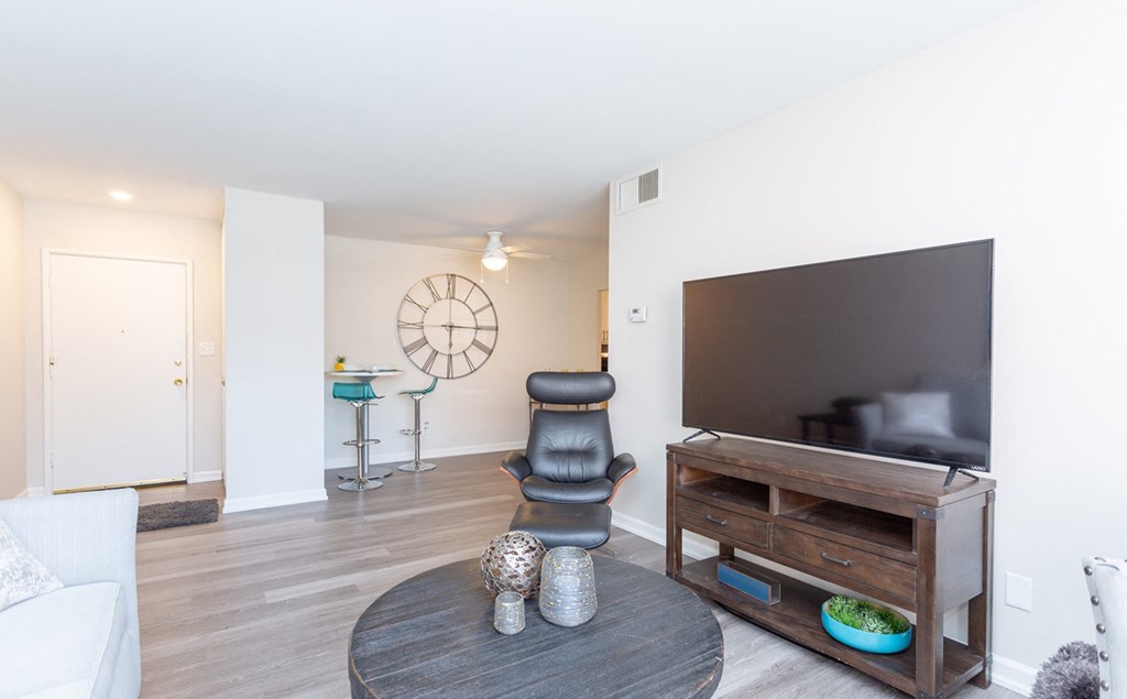 a living room with a large tv and a table with a chair