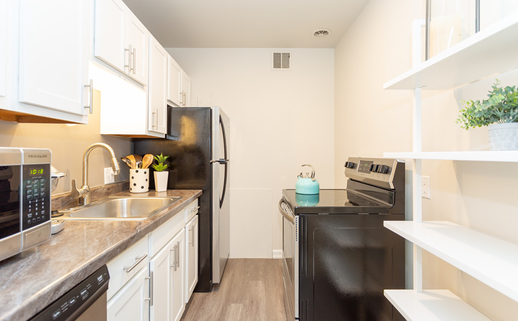 a kitchen with stainless steel appliances and a black refrigerator