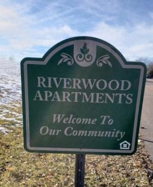 a sign that says riverwood apartments is welcome to our community