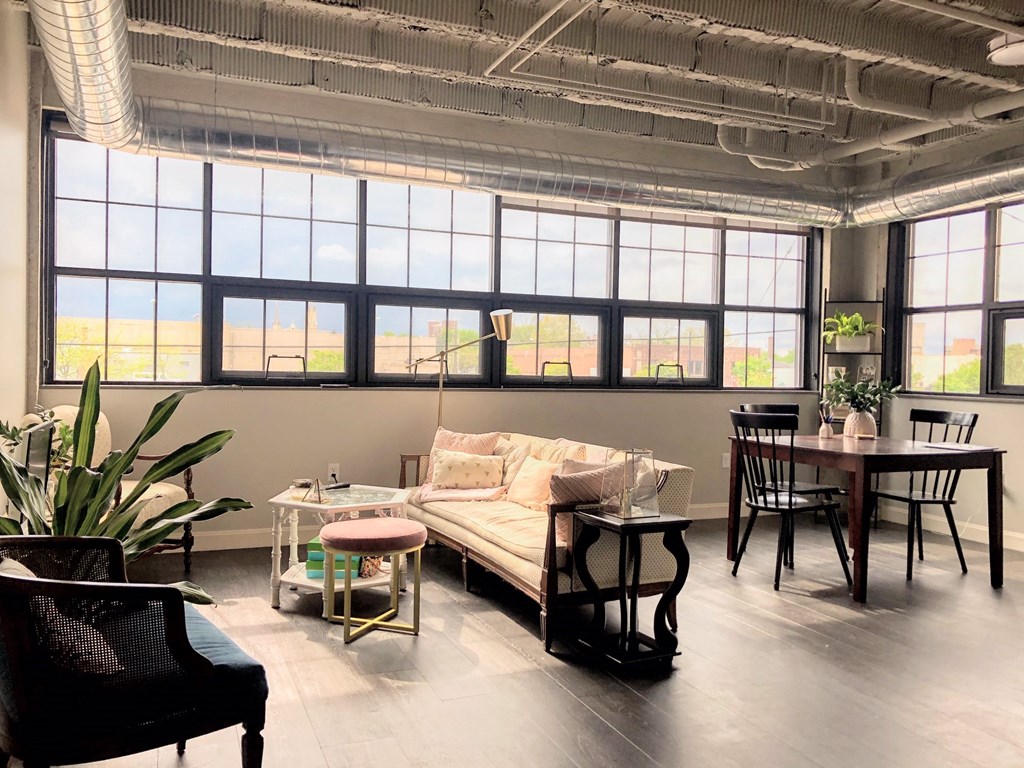 a living room with a couch and a table in front of windows