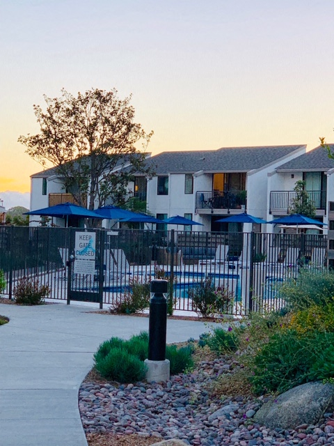 an apartment building with a pool and a gate