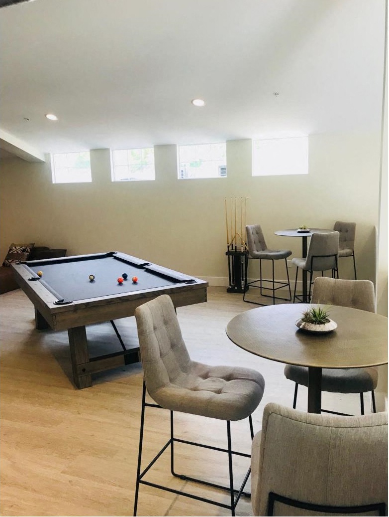 a game room with a pool table and tables