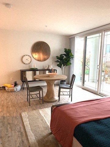 a room with a bed and a table and a clock on the wall