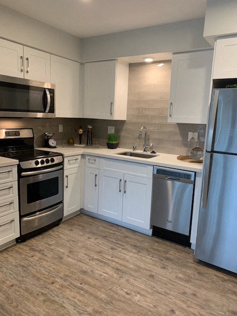 a kitchen with white cabinets and stainless steel appliances