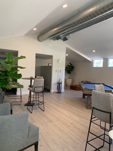 a game room with a pool table and chairs