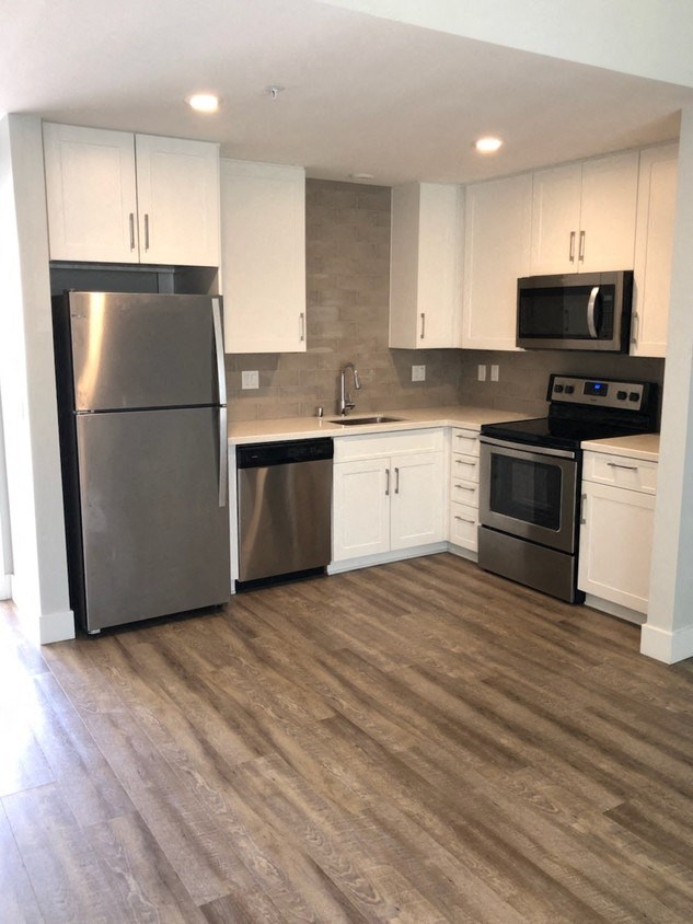 a kitchen with stainless steel appliances and white cabinets