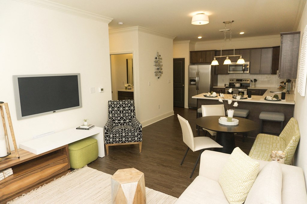 a living room and kitchen with a table and chairs and a television