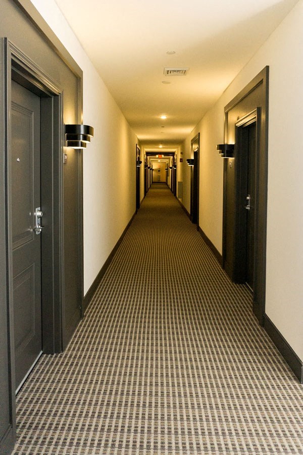 a long hallway with doors and a checkered floor