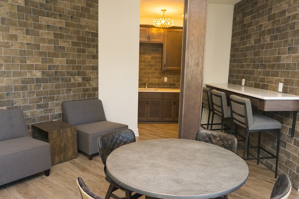 a dining area with a table and chairs and a kitchen with a bar