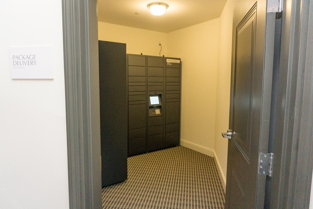 a hallway with a door to a room with a toilet and drawers