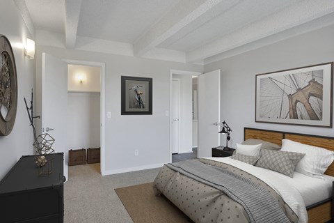 A bedroom with a large bed and a painting on the wall.
