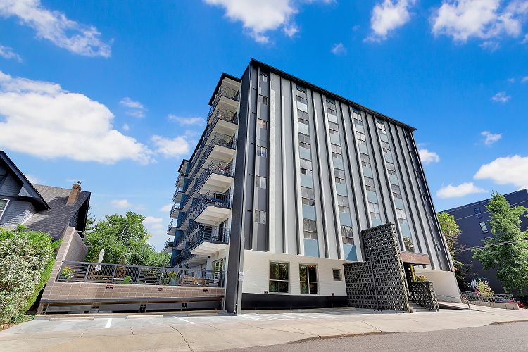 a large apartment building with a staircase and a blue sky