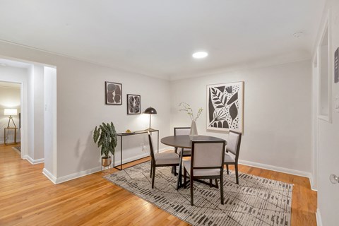 A dining room with a table and chairs.