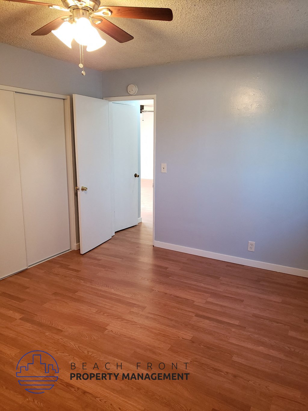 an empty living room with wood floors and blue walls