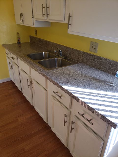 a kitchen with white cabinets and a granite counter top